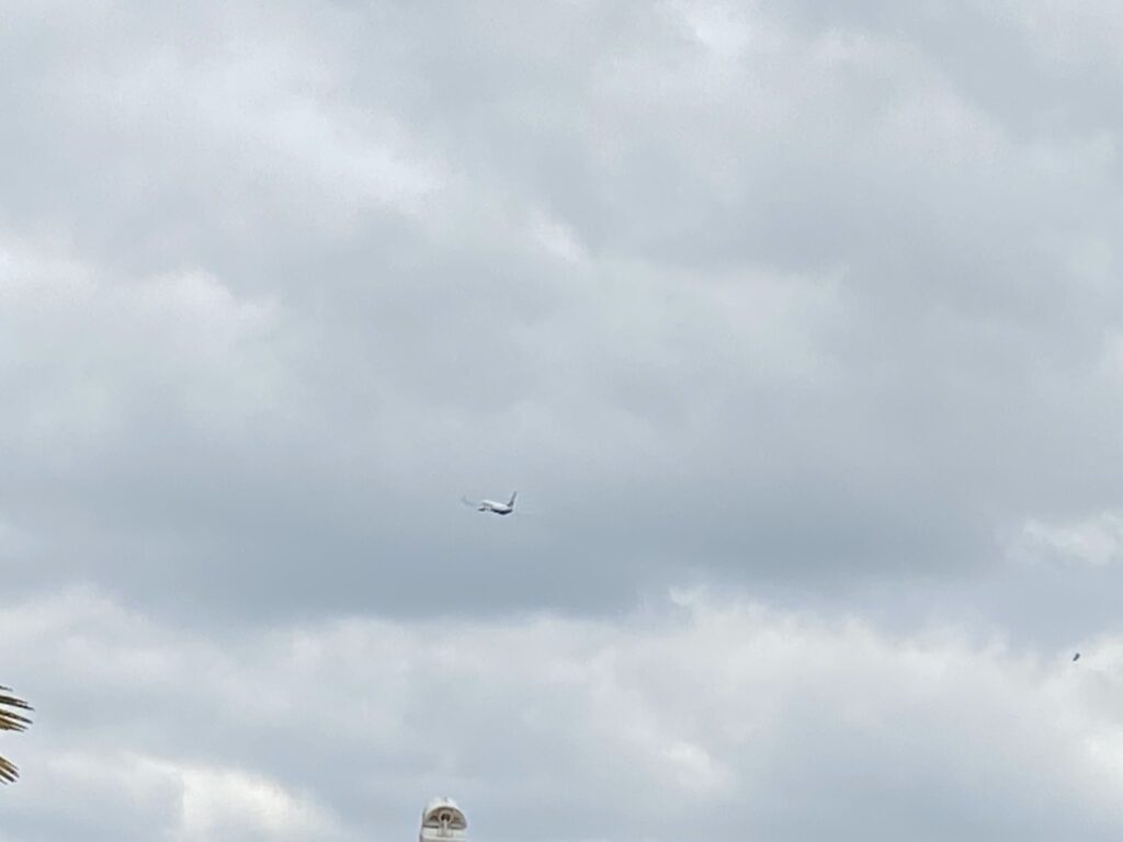 A passenger aircraft beneath low grey cloud over Sheldon