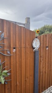 A newly repaired wooden fence and post between neighbouring gardens