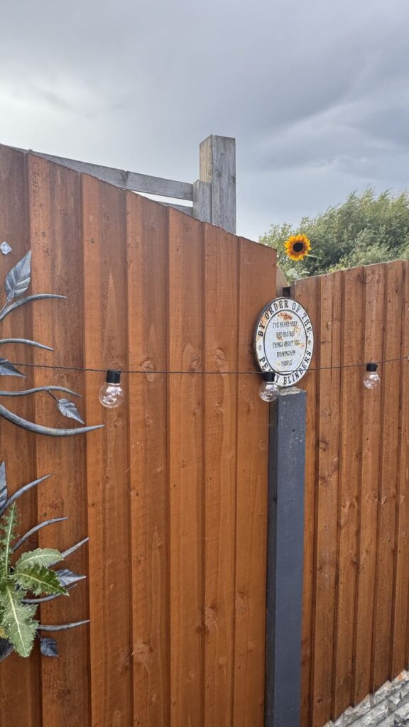 A newly repaired wooden fence and post between neighbouring gardens