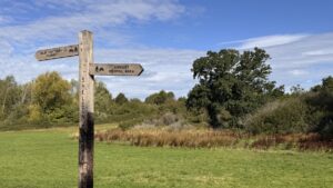 Fingerpost in Sheldon Country Park pointing towards Birmingham Airport viewing area and Old Rectory Farm
